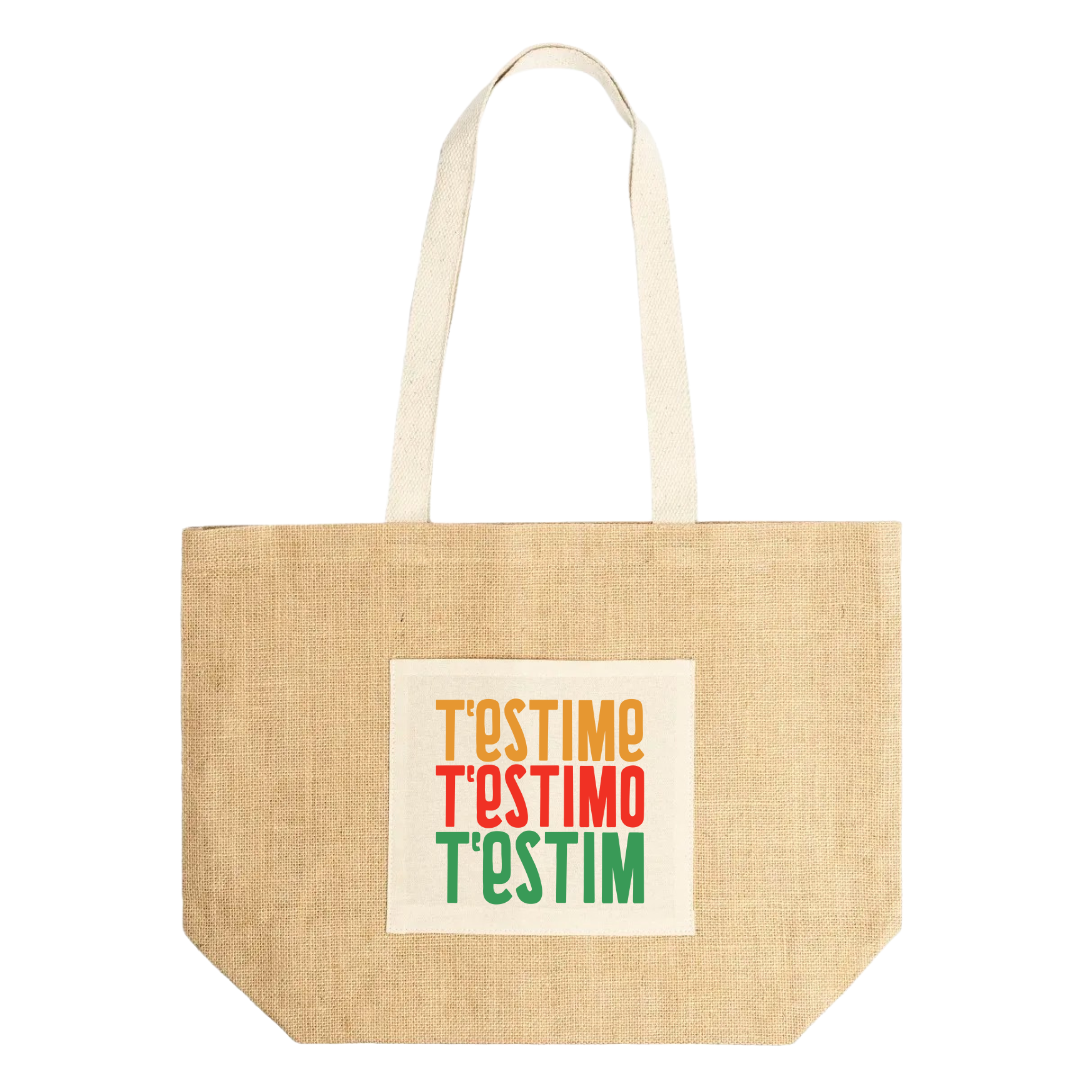 Bossa de platja de jute amb anses de cotó i disseny frontal amb el text “T’estime, T’estimo, T’estim” en colors groc, roig i verd.