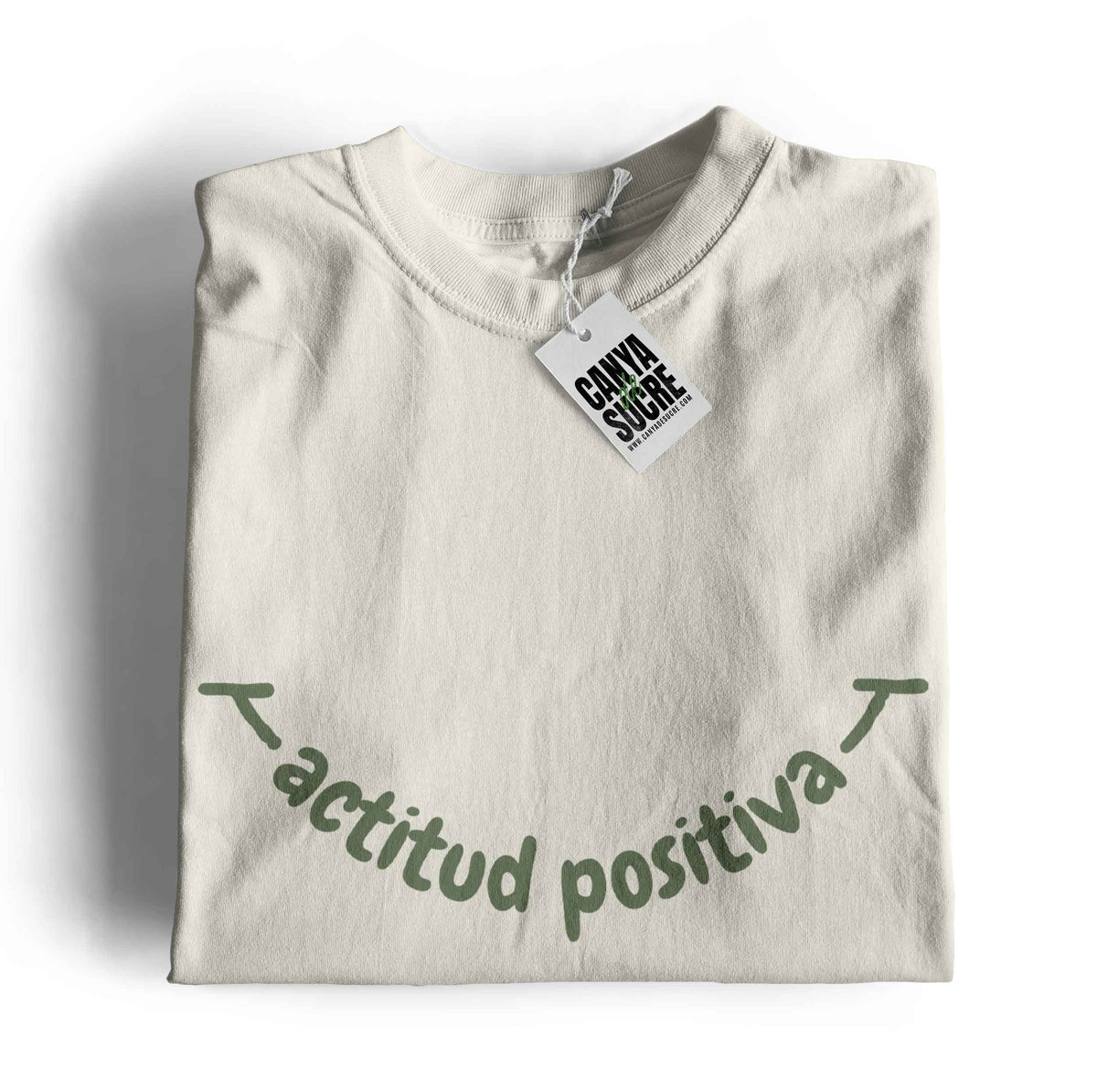 Samarreta color blanc vintage amb la frase actitud positiva en verd al pit formant un somriure. Disseny de Canya de Sucre