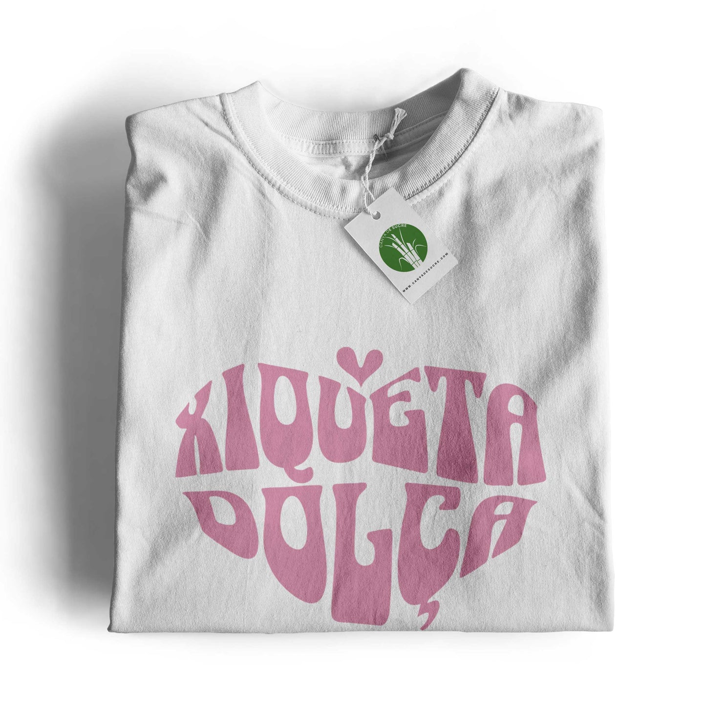 Samarreta unisex amb el text “Xiqueta dolça” en tipografia rosa formant un cor, disponible en color blanc, disseny de la marca valenciana Canya de Sucre.