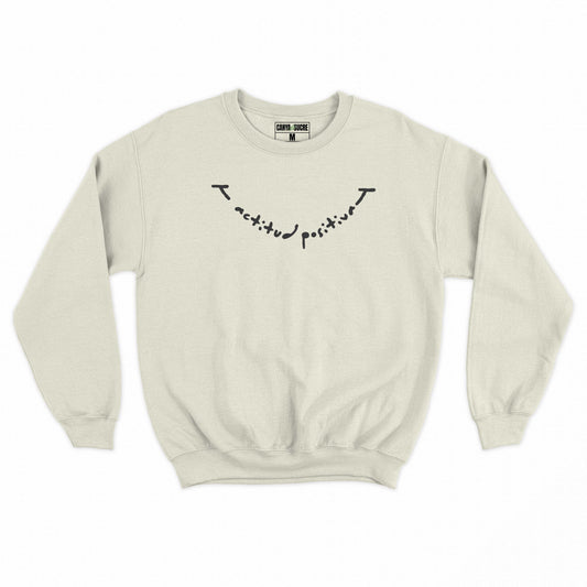 Dessuadora beige amb el missatge “actitud positiva” en lletra manuscrita negra —disseny original de Canya de Sucre.