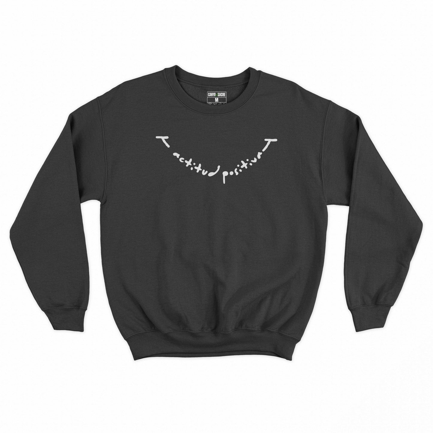 Dessuadora negra amb el missatge “actitud positiva” en lletra manuscrita blanca —disseny original de Canya de Sucre.