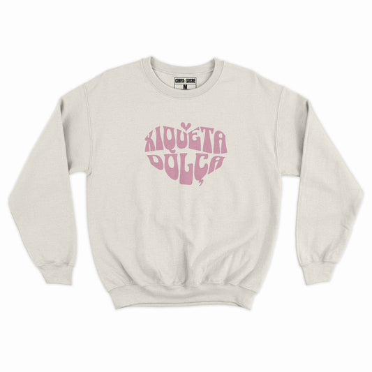 Dessuadora blanc vintage amb el disseny “Xiqueta Dolça” al pit en tipografia retro groovy rosa amb forma de cor, de Canya de Sucre.
