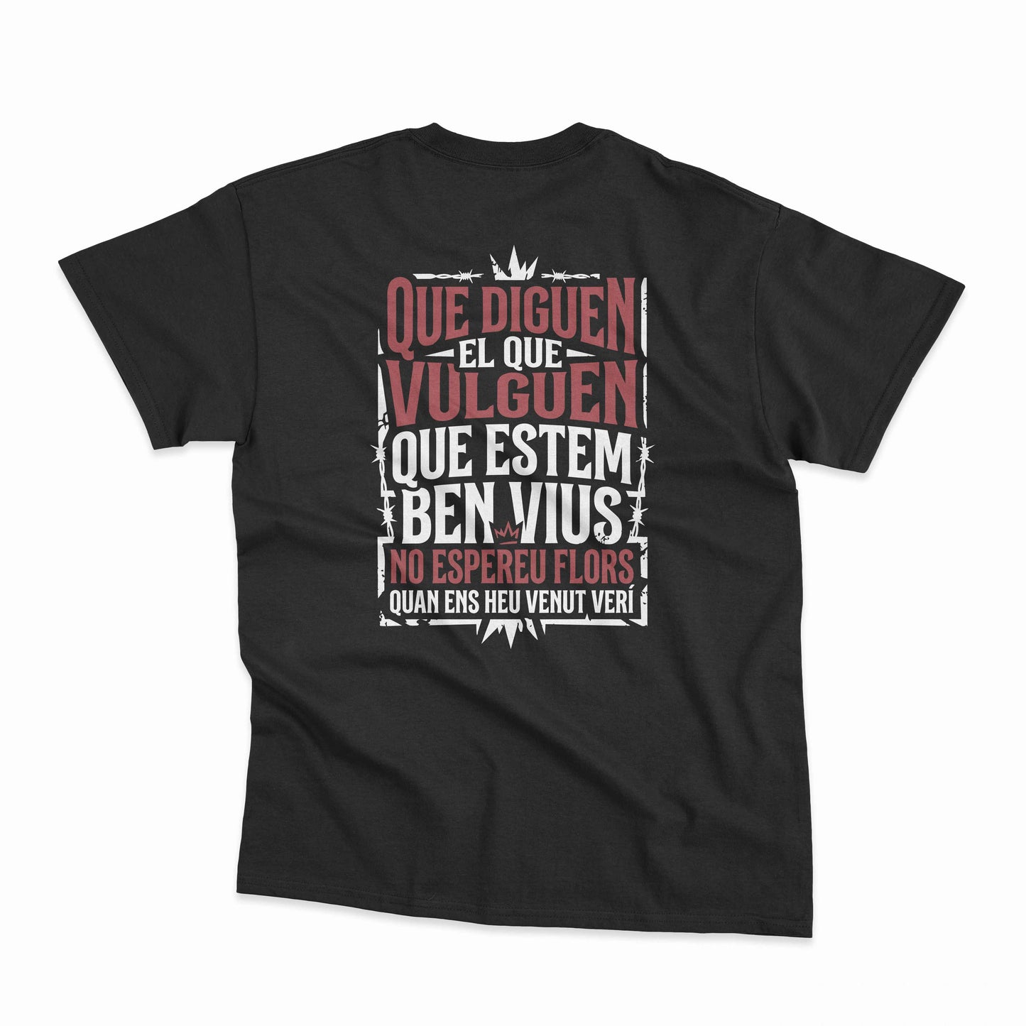 Samarreta unisex negra amb la frase "Que diguen el que vulguen, que estem ben vius, no espereu flors quan ens heu venut verí" de La Gossa Sorda a l'esquena, de Canya de Sucre.