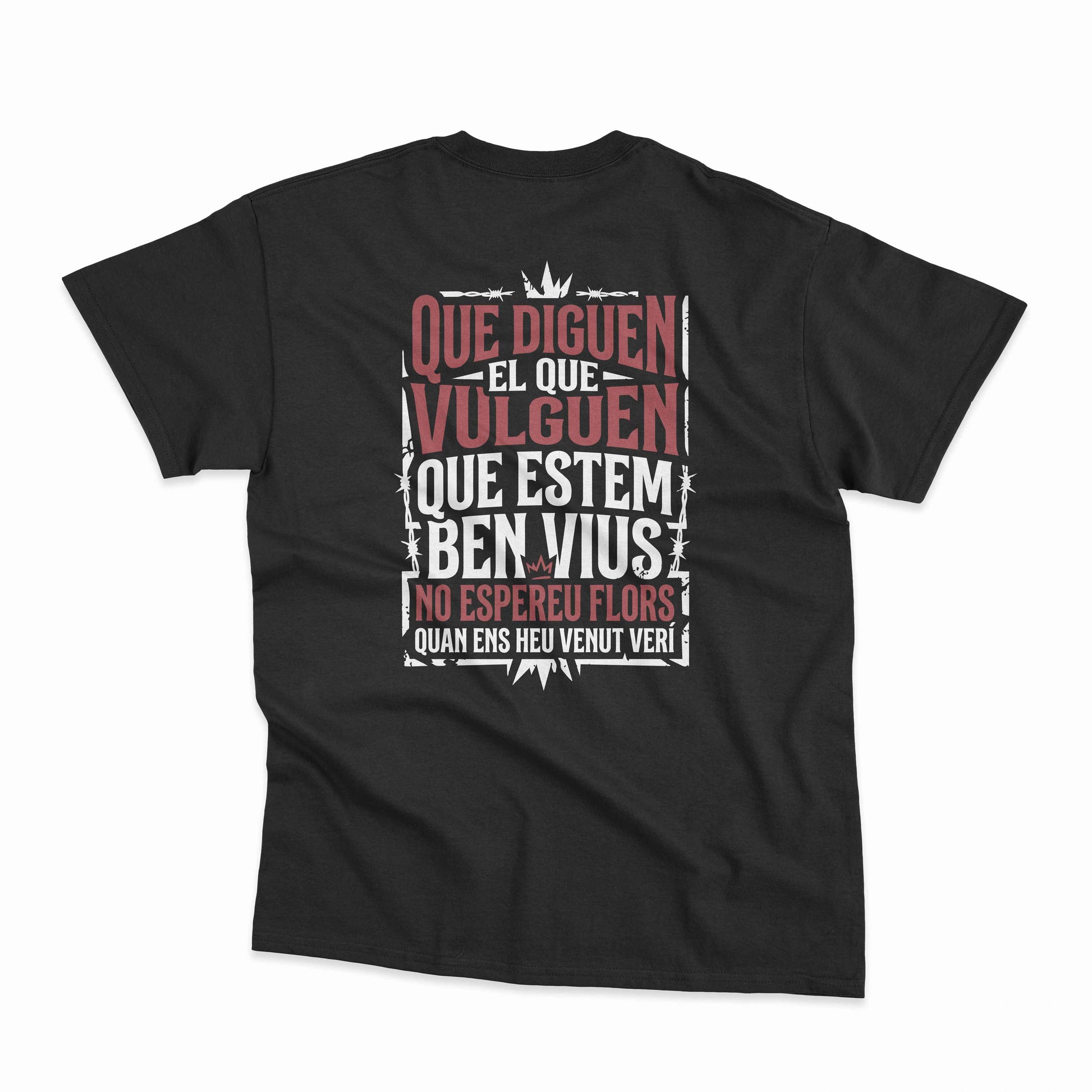 Samarreta unisex negra amb la frase "Que diguen el que vulguen, que estem ben vius, no espereu flors quan ens heu venut verí" de La Gossa Sorda a l'esquena, de Canya de Sucre.