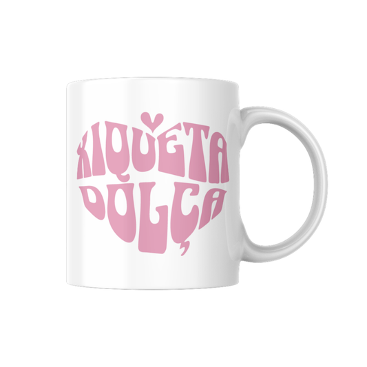 Tassa de ceràmica blanca amb la frase “Xiqueta dolça” en tipografia rosa formant un cor, disseny tendre en valencià de la marca Canya de Sucre.